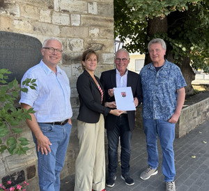 Ministerialdirektorin Katharina Heil übergibt einen Förderbescheid an die Kirchengemeinde Bad Neuenahr-Ahrweiler. Mit auf dem Foto auch drei Vertreter der Kirchengemeinde.